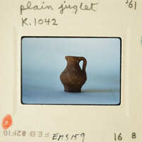 Brown clay vase on white surface.
