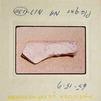 A photograph of an artifact, possibly pottery, with visible markings and textures.