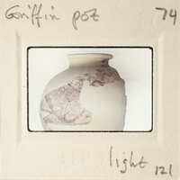 A photograph of a broken pot with a handwritten label on it.