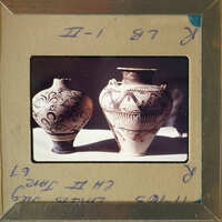 Two antique vases with intricate designs on display.