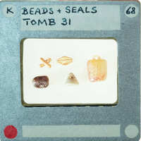 A collection of small objects, including beads and seals, on white background.