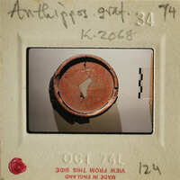 A photograph of an ancient sherd with visible cracks and damage, taken on October 7, 1974.