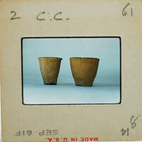 Two brown ceramic pots on a white surface.