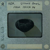 A black and white photograph of a stone bowl with a label.