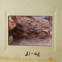 A rock formation with a small hole at the bottom, likely taken from an angle looking up.