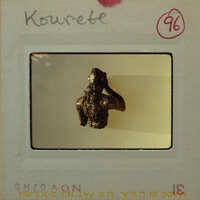 Small sculpture on display of person from the torso up from the rear.