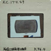 A small, square object with a label on it, possibly an artifact or specimen.