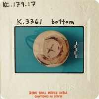 Old photograph of an object with markings, possibly a ball or sphere, on a blue background.