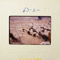 Old photograph of stone ruins with handwritten numbers and date on border.