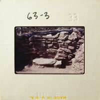 Stone ruins with a bench inside, photographed on an old film slide.