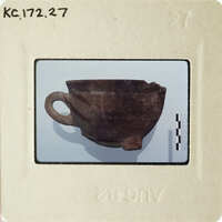 An antique ceramic cup with a handle, photographed on a white background and displayed within an object tag.