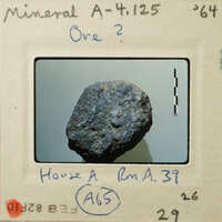 A photograph of a dark, rough-textured rock specimen.