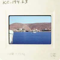 A photograph of a serene coastal scene with a boat on the water.