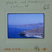 A photograph of a scenic coastal landscape with mountains and the ocean.