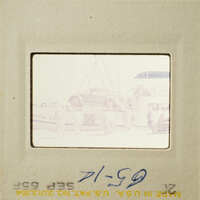 People standing near boats on a dock.