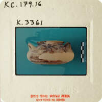 A photograph of an artifact, possibly a clay pot, with visible signs of age and wear.