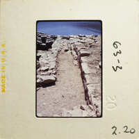 Stone steps leading down to water, with rocks and dirt on either side.