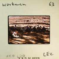 A group of people sitting on the ground, engaged in conversation or activity.