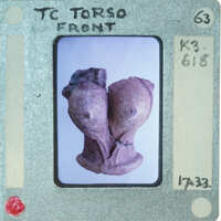 Terracotta figurine torso from front.