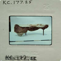 A photograph of a plaster fragment from the side on display.