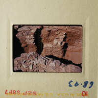 The photo shows an ancient stone structure, possibly ruins, with layers of rock and dirt.