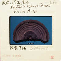 Ancient pottery artifact on display with identification label.