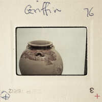 A photograph of a clay pot with markings and an image of a face on it, taken by Griffin.