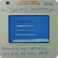 A collection of bone needles displayed on a blue background.