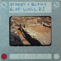 A photograph of an ancient stone wall with a label on the front.