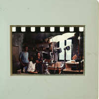 A vintage photo of a man and woman with film equipment.