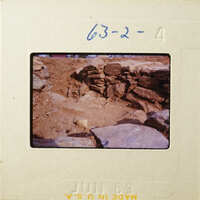 Dirt and rock formation with stone wall.