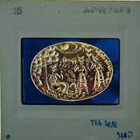 Gold ring with intricate designs and characters on a blue background.