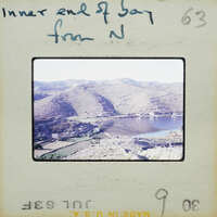 A vintage photo of a mountainous landscape with a body of water.