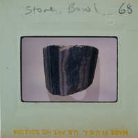 A photograph of a dark, marbled stone bowl with a label on it.