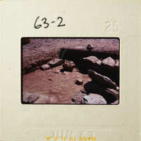 Ancient ruins with stone walls and dirt ground.