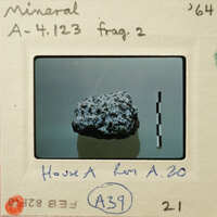 A photo of a mineral sample on a mount with labels and measurements.