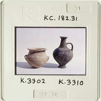 Two antique vases with different designs and colors, displayed on a table.