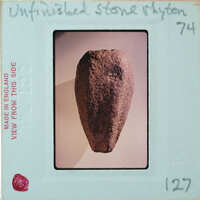 Cylindrical stone tapering towards the bottom, from the side.