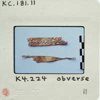 Two photographs of a small, thin, gold-colored object with intricate designs.