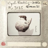 An old, weathered clay vase with a handle and spout.