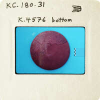 A circular, red object with cracks on a blue surface.