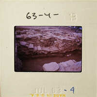 Ancient ruins with stone walls and dirt ground, photographed on a film strip.