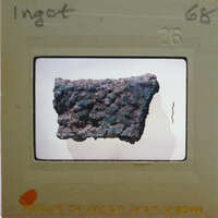 A close-up photo of a metallic object with a greenish patina, possibly an artifact or a piece of metalwork.