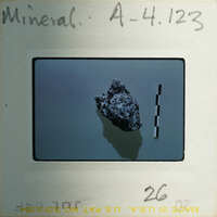 Slide of a rock with measurement lines on a background.