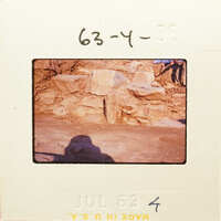 Old photograph of stone ruins with a person standing nearby, dated July 1963.