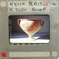 Reassembled vase with swirling patterns, displayed on a white stand.