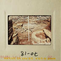 The photo shows an underground cave with a small pit at the bottom.