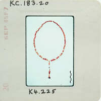 Red beaded necklace on a white background.