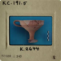 A cracked clay cup on a blue background with measurement marks.