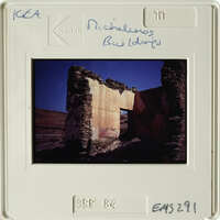 Old stone ruins with blue sky and red-orange hues.